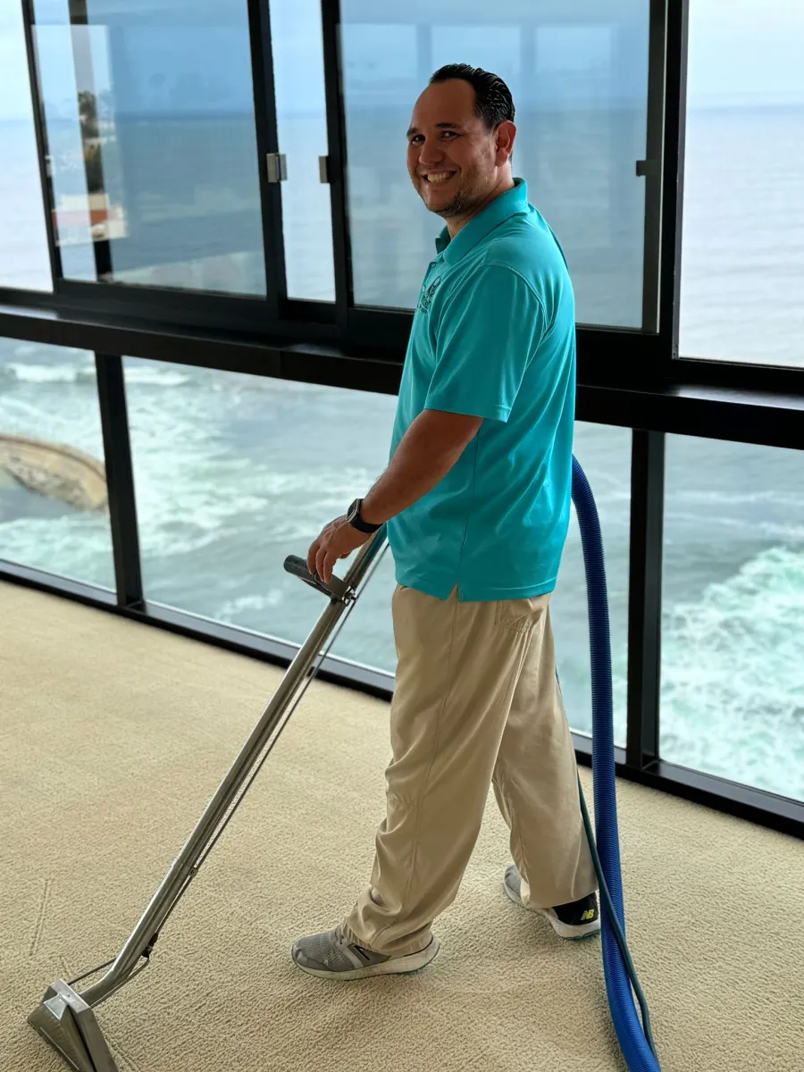 Hot-water extraction wand on carpet beside ocean-view windows Hot-water extraction wand on carpet beside ocean-view windows