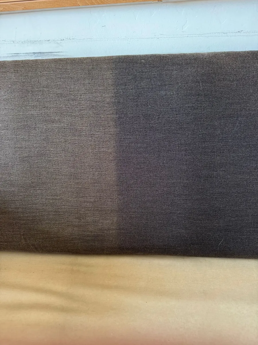 Dark fabric panel half cleaned, before and after